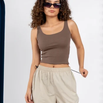 Mujer usando top marrón de tirantes y pantalón cargo beige, look casual femenino